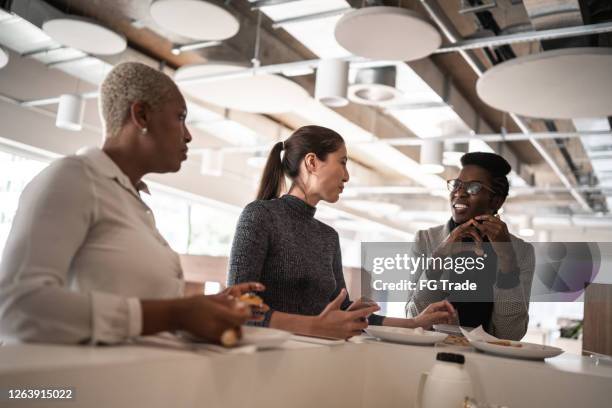 仕事で休憩時間に食事や話をするビジネスの同僚 - inspiring women luncheon ストックフォトと画像