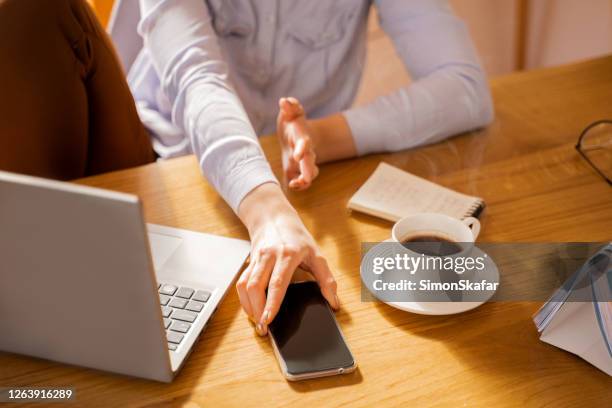 high angle view of hand reaching for phone - shirt grab stock pictures, royalty-free photos & images