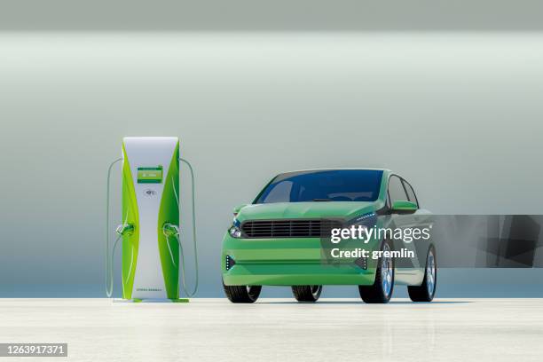 coche eléctrico moderno con estación de carga eléctrica - little car fotografías e imágenes de stock