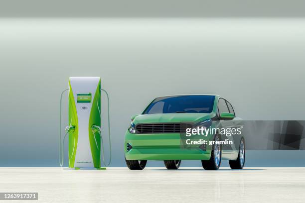 modern electric car with electric charging station - green colour car stock pictures, royalty-free photos & images