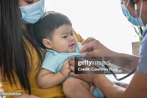 Pediatrician listening to baby boys lungs Pediatrician listening to baby boys lungs