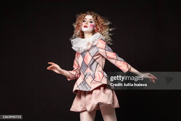 female jester jumping and looking away - theatre costume stock pictures, royalty-free photos & images