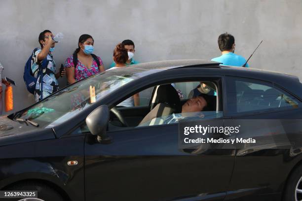 Person waits asleep in the car as health department opens 300 nursing jobs on August 4, 2020 in Cancun, Mexico. 1000 nursing specialists went to the...