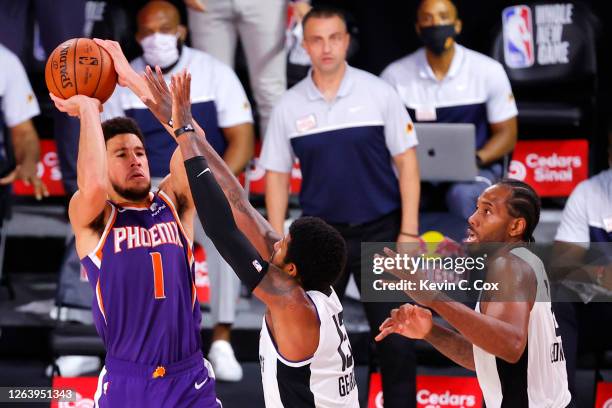 Devin Booker of the Phoenix Suns shoots the game winning basket over Paul George of the LA Clippers at The Arena at ESPN Wide World Of Sports Complex...