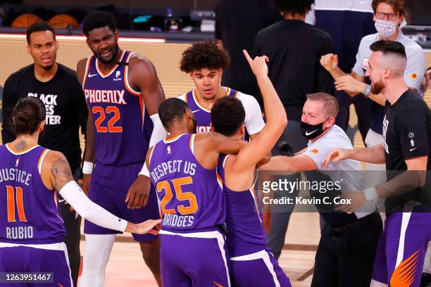 Devin Booker of the Phoenix Suns celebrates with teammates after scoring the game winning basket against the LA Clippers at The Arena at ESPN Wide...