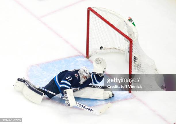 Connor Hellebuyck of the Winnipeg Jets stops a shot by Matthew Tkachuk of the Calgary Flames in the first period in Game Three of the Western...