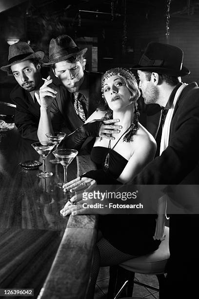 caucasian prime adult retro female sitting at bar surrounded by suitors. - 1920s flapper girl stock pictures, royalty-free photos & images