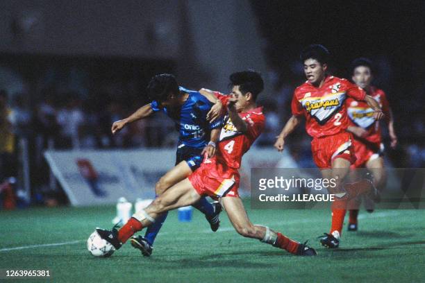Yoshiyuki Matsuyama of Gamba Osaka is tackled by Toshihisa Iijima of Nagoya Grampus Eight during the J.League Suntory Series match between Nagoya...