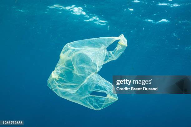 plastic bag floating in ocean - plastic foto e immagini stock