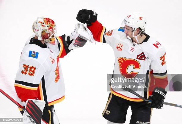 Cam Talbot of the Calgary Flames celebrates the 6-2 win over the Winnipeg Jets with teammate Sean Monahan after Game Three of the Western Conference...
