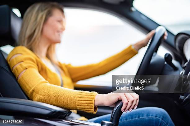 fermez-vous vers le haut des vitesses de changement de main de jeune femme, conduisant une voiture. - levier de vitesse photos et images de collection