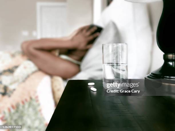 ailing woman rests in bed - paracetamol stockfoto's en -beelden