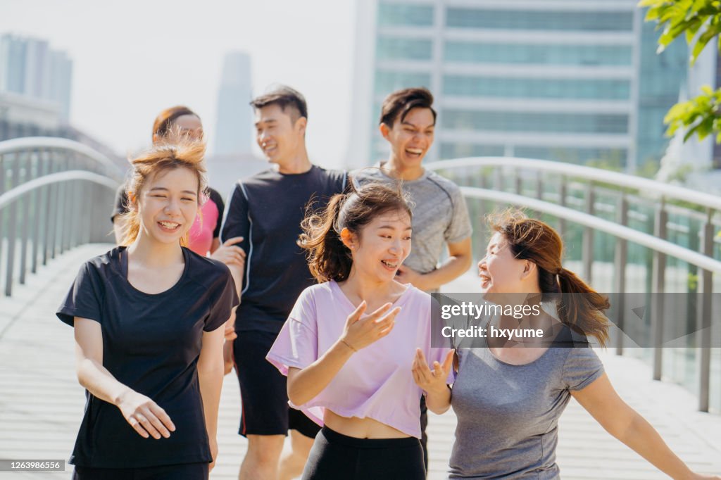 Group of young asian jogging through city park
