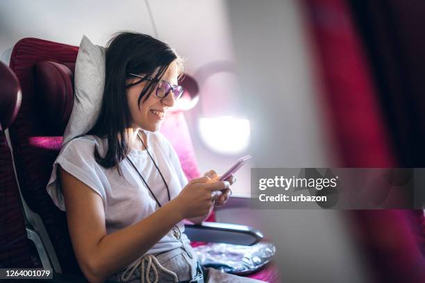 reading news or messages on an airplane - airplane phone stock pictures, royalty-free photos & images