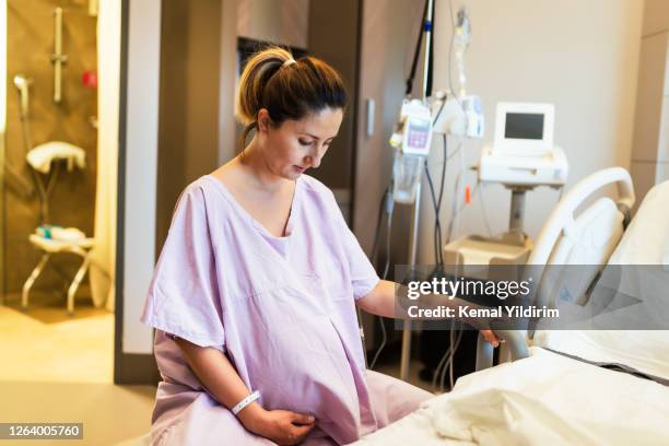 jonge zwangere vrouw in de het ziekenhuisafdeling die op geschiktheidsbal zit en klaar om een baby te leveren. - labor childbirth stockfoto's en -beelden