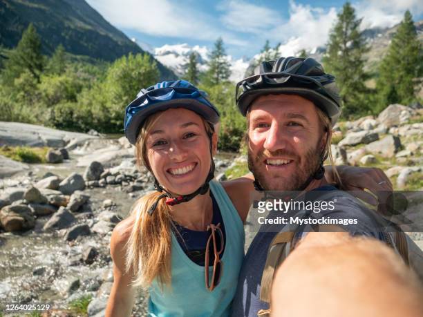 mountain bikers taking selfie on trail - young couple hiking stock pictures, royalty-free photos & images