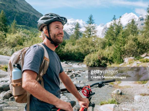 mann auf mountainbike mit blick auf panorama - mountain biker stock-fotos und bilder