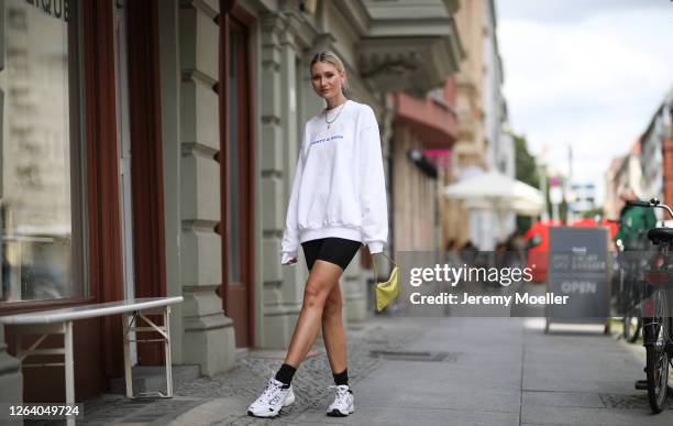 Carolin Niemczyk wearing New Balance sneaker, Sporty & Rich sweater, Prada bag and Champion short on August 03, 2020 in Berlin, Germany.