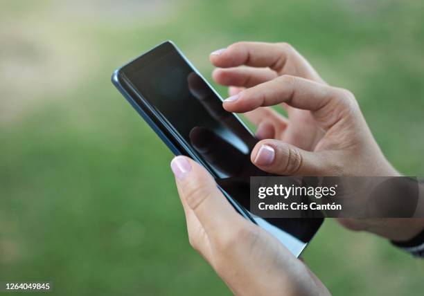 female hand using smartphone outdoors - inzoomen stockfoto's en -beelden