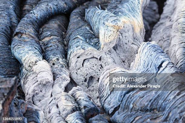 detailed view of basaltic undulating surface of frozen volcanic lava, wrinkled in folds and rolls resembling twisted rope. beautiful lava plain landscape on area eruption active volcano - rope lava stock pictures, royalty-free photos & images
