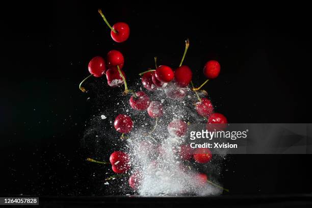 cherry dancing in mid air with high speed sync. - frozen fruit stock pictures, royalty-free photos & images