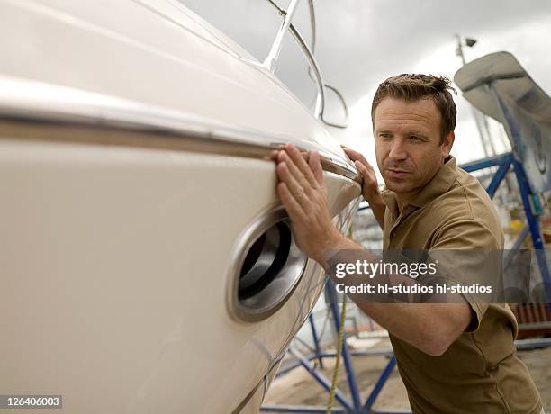 man pushing boat at harbor - 40 44 jahre 個照片及圖片檔