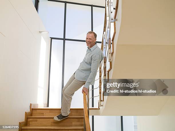 portrait of man smiling on staircase - sliding foto e immagini stock