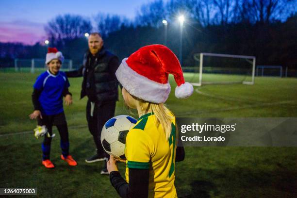 fußball-vater trainiert fußball-tochter-team während einer trainingseinheit - christmas and football stock-fotos und bilder