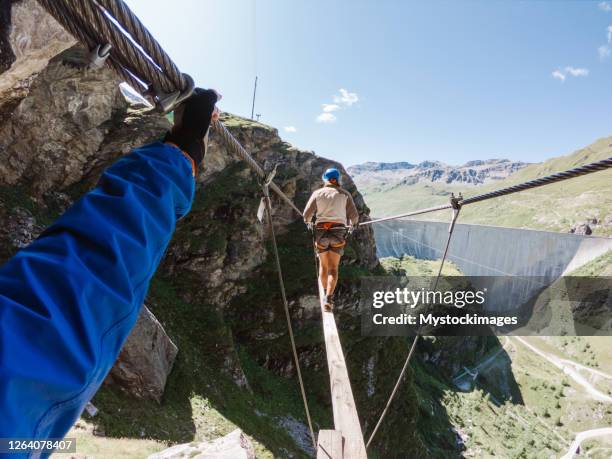 pov par på via ferrata passerar apa bro - hängbro bildbanksfoton och bilder