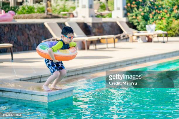 kleiner junge bereit, ins schwimmbad zu springen - inflatable ring stock-fotos und bilder