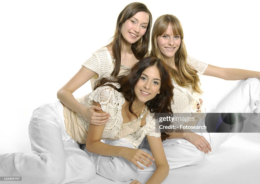Portrait of three young women sitting together and smiling