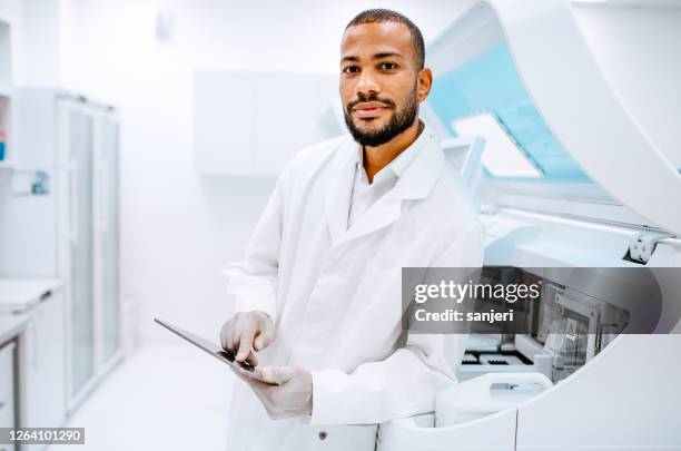 retrato de um cientista em laboratório, segurando um tablet digital - oncologista - fotografias e filmes do acervo