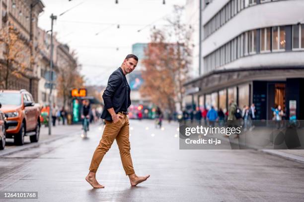 barfota man korsar stadsgatan - barefoot bildbanksfoton och bilder
