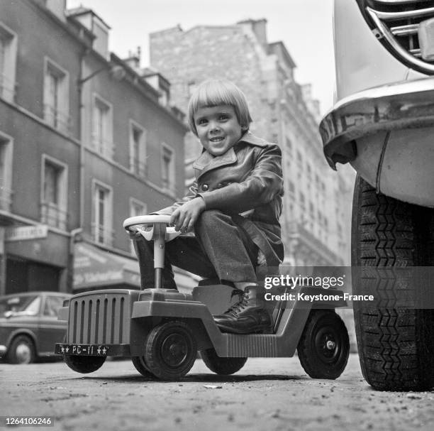 Enfant monté sur une voiture en plastique en octobre 1969, France.