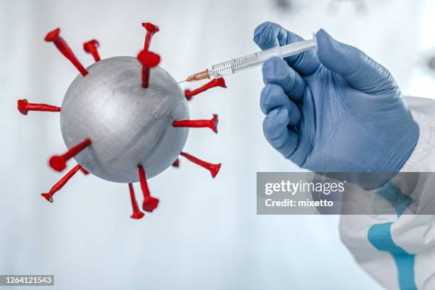 doctor injecting vaccine to covid-19 molecules - fighting covid stock pictures, royalty-free photos & images