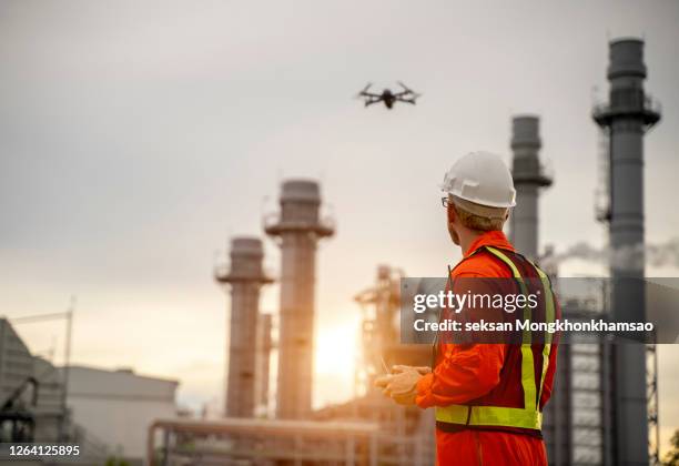 young engineer piloting drone at building site. video surveillance or industrial inspection. - video reviewed stock pictures, royalty-free photos & images