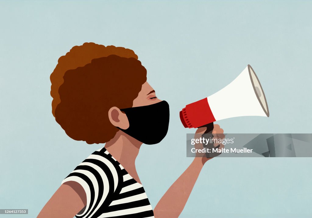 Black woman in face mask using megaphone