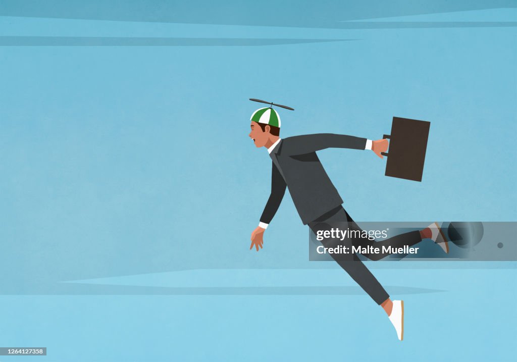 Businessman in propellor hat flying in sky