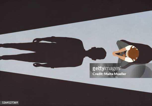 woman sitting before looming male shadow - violence stock illustrations
