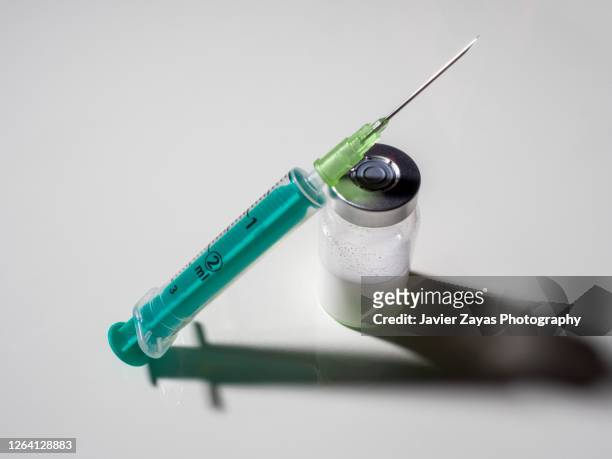 syringe and phial containing drug dose - steroid stock-fotos und bilder