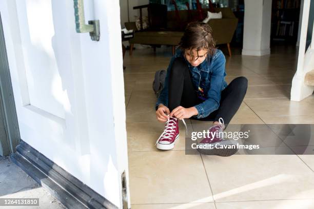 teen girl sits on the tile floor and ties her brand new shoes - thousand oaks stock pictures, royalty-free photos & images