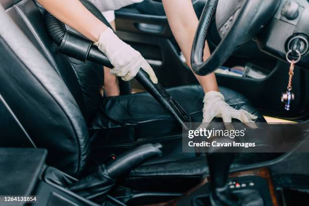 young woman cleaning the interior of his car with vacuum cleaner - clean car interior stock pictures, royalty-free photos & images