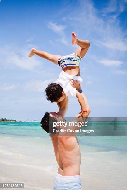 father and son playing at a beach in the caribbean. - grand bahama stock pictures, royalty-free photos & images