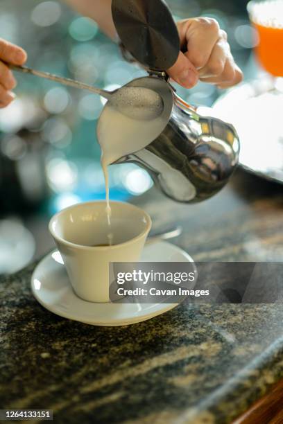 hands of young adult caucasian female barista at work preparing - roma capucino stock pictures, royalty-free photos & images