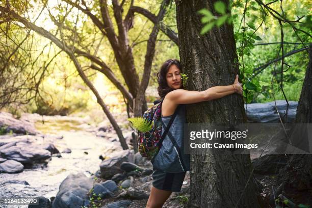 young woman hugging a tree. she is happy. - activist stock pictures, royalty-free photos & images