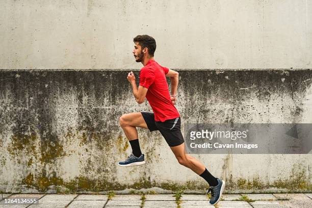 young man running fast in the park - human body part stockfoto's en -beelden