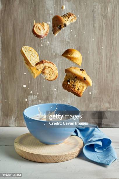 blue bowl with with splashes of milk flying chocolate muffins, p - chocolate milk splash stock pictures, royalty-free photos & images