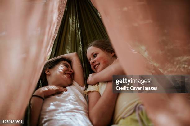 two teen girls laying in hammock smiling and laughing - denver summer stock pictures, royalty-free photos & images