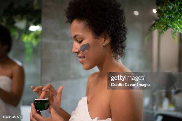 glad african american lady during skin care routine - evening indulgence stock pictures, royalty-free photos & images