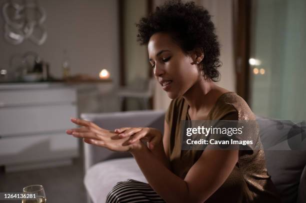 black woman applying cream on hands - applying stock photos et images de collection